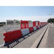 Red and white Defender50 crash-tested barriers with fencing panels assembled along an open site perimeter for traffic or pedestrian control.
