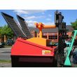 Orange skip compactor forklift attachment in use with red skip bin, designed for compacting waste and maximising bin capacity.