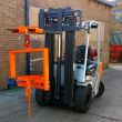 Heavy-duty forklift with adjustable hook and crane drum tilter attachment securing steel drum for safe lifting and controlled tipping.