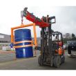 Industrial crane drum tilter forklift attachment lifting and tilting blue steel barrel with secure straps for warehouse handling.