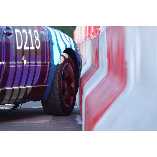 Close-up of car tyre pressed against Defender50 safety barrier – real-world test validating side impact resilience.