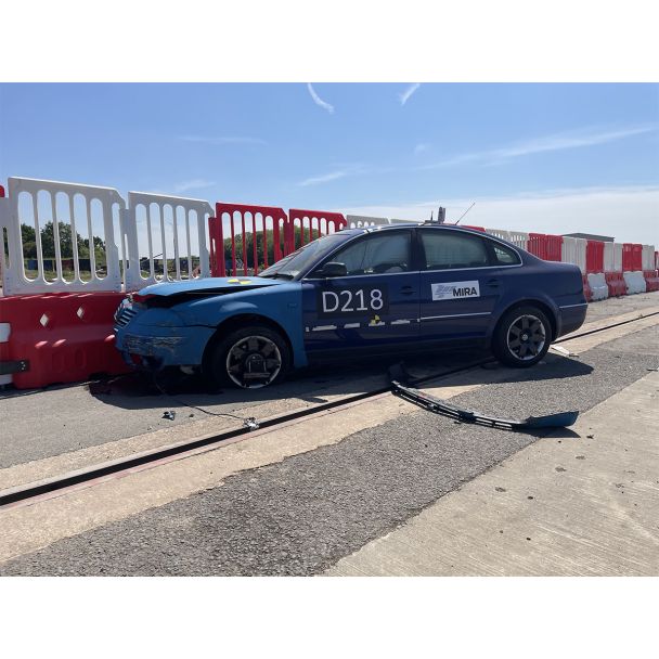 Crash-tested Defender50 barrier showing minimal deflection after direct frontal vehicle collision on test track.
