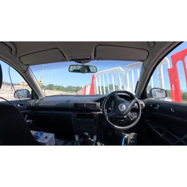 Interior view of crash test vehicle moments before Defender50 impact, showing alignment with red-white barrier panels.