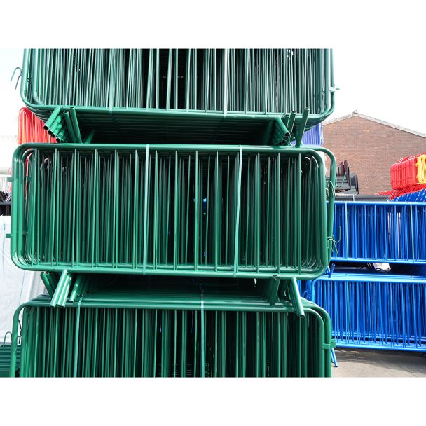 Front-facing view of green barriers, showing dense packing and welded vertical bars.