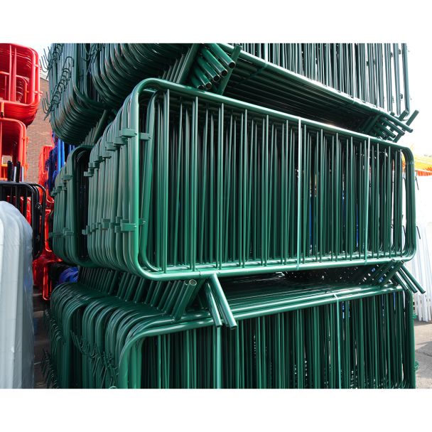 Angled view of green barriers, showing dense packing, welded vertical bars, curved frames and welded joints.