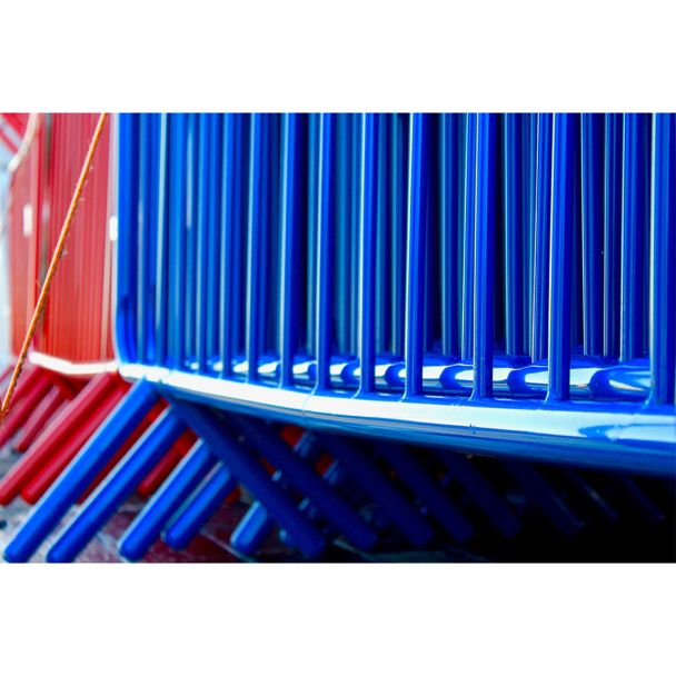 Close-up of blue barrier stack, focusing on interlocked curved frames and welded joints.