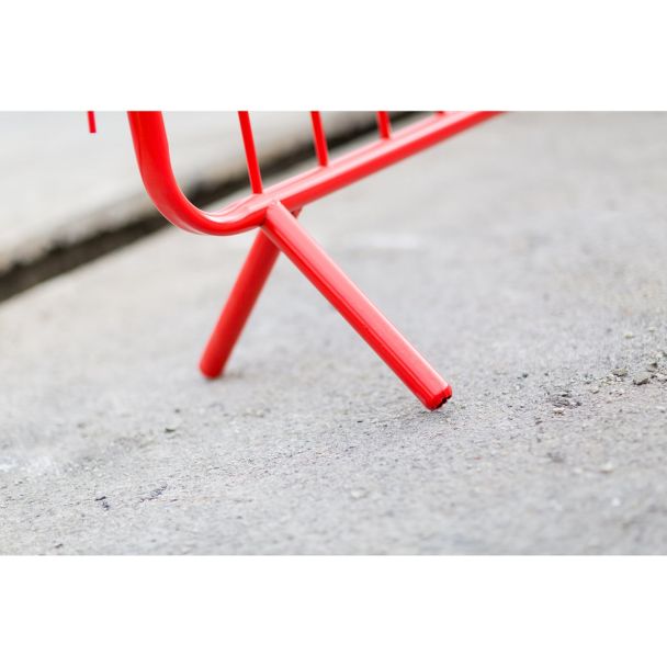 Detailed shot of one leg of the red barrier touching the ground, emphasising the anti-tip design and powder-coated finish.